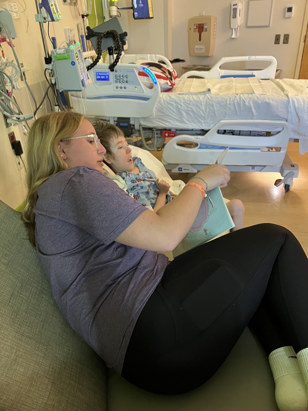 Ava reading to Jackson in a hospital room