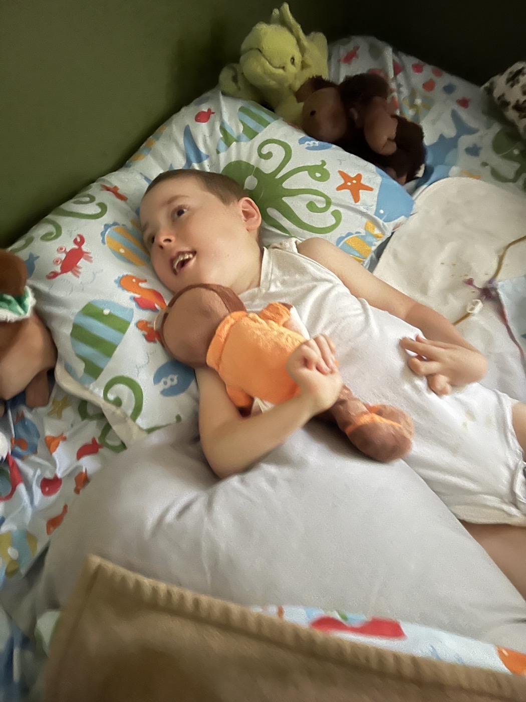 Jackson in bed with his dolls and stuffed animals